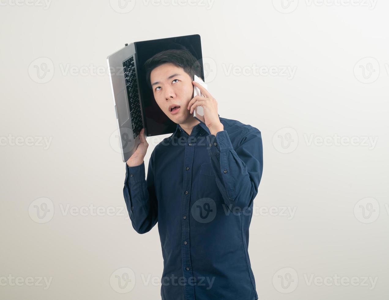 Asian man talking smartphone or mobile phone and hand holding laptop photo
