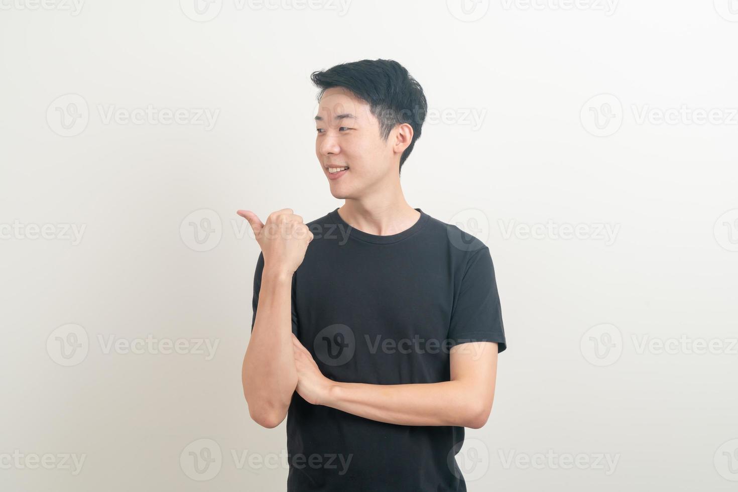 Hombre asiático con la mano apuntando o presentando sobre fondo blanco. foto