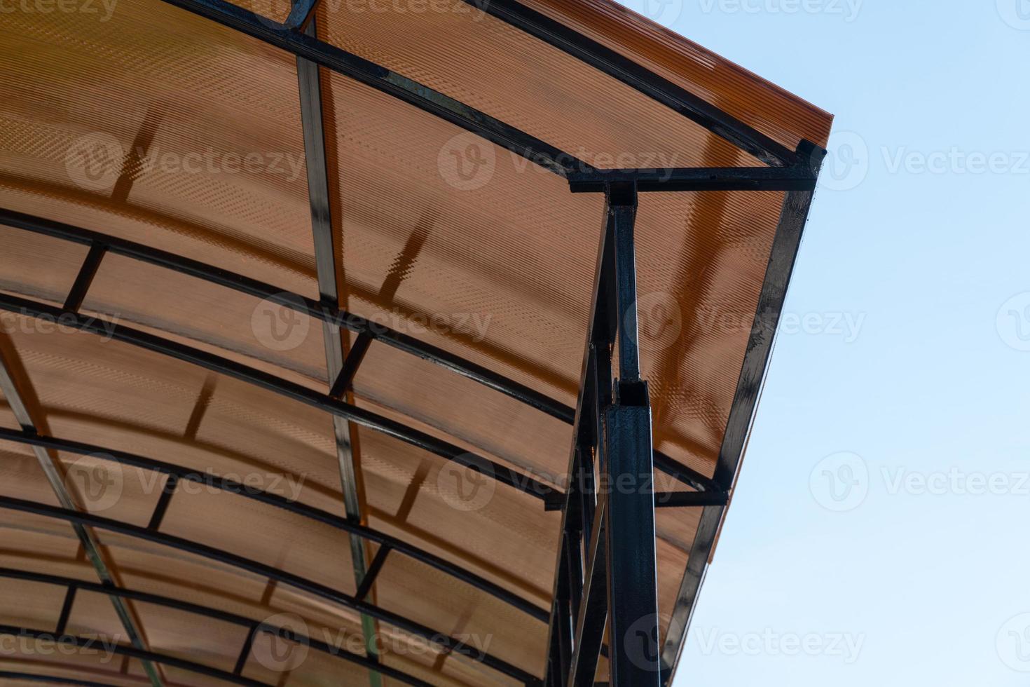 plastic carport. brown transparent roof made of polycarbonate with metal structures photo