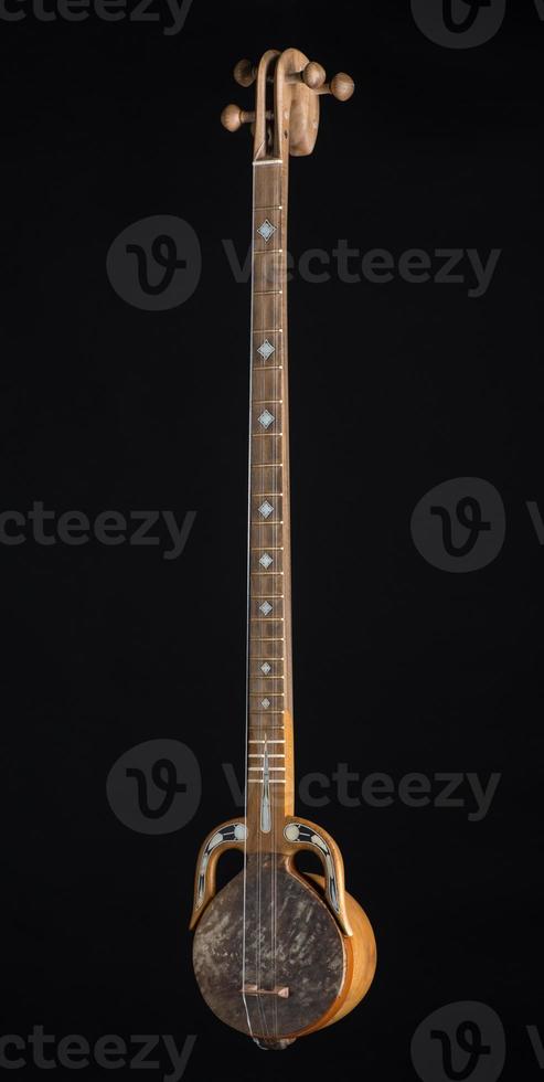 ancient Asian stringed musical instrument on black background with backlight photo