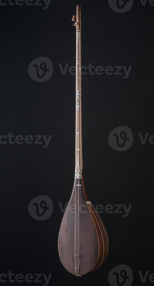 ancient Asian stringed musical instrument on black background with backlight photo