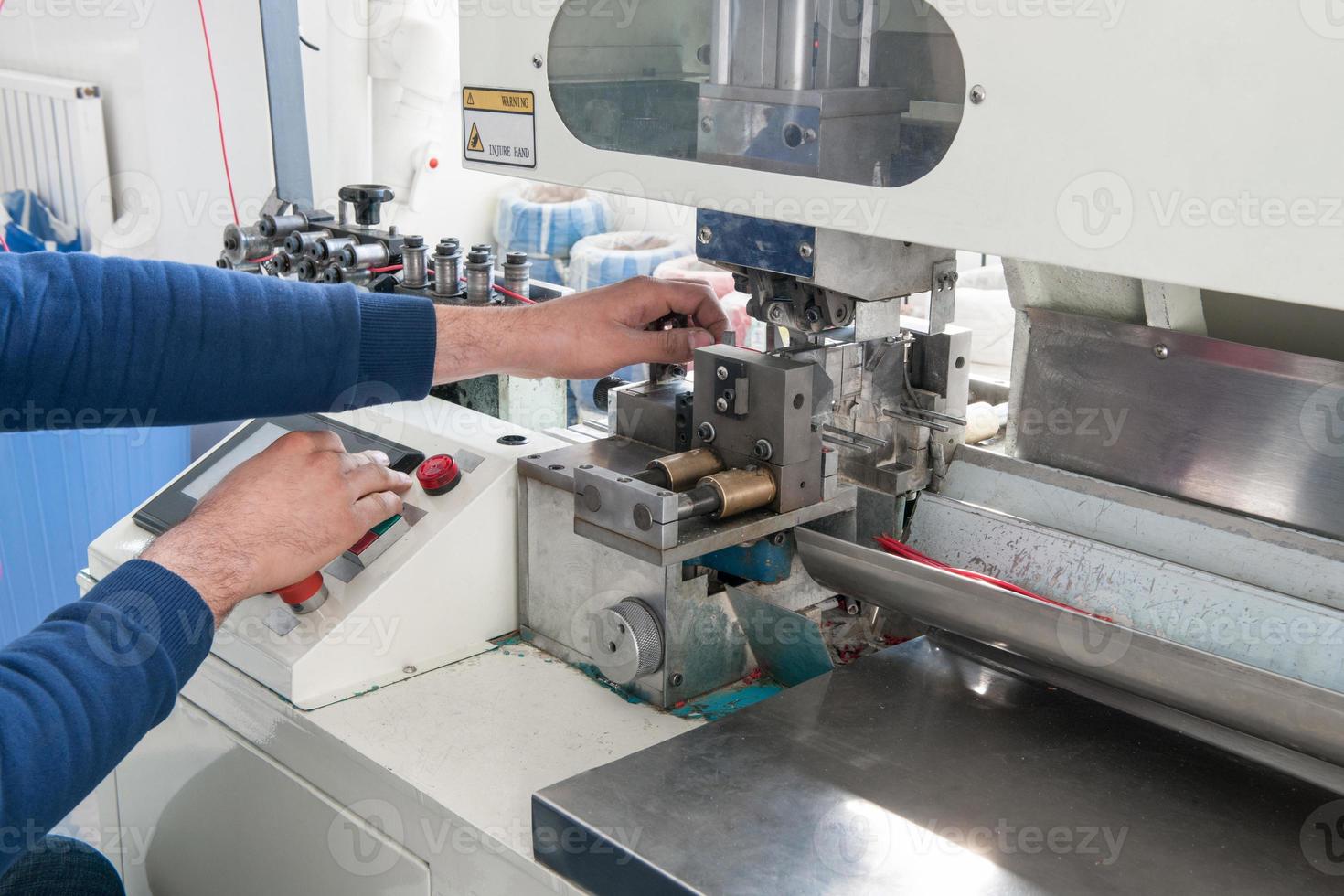 hands working on industrial machine for cutting cable photo