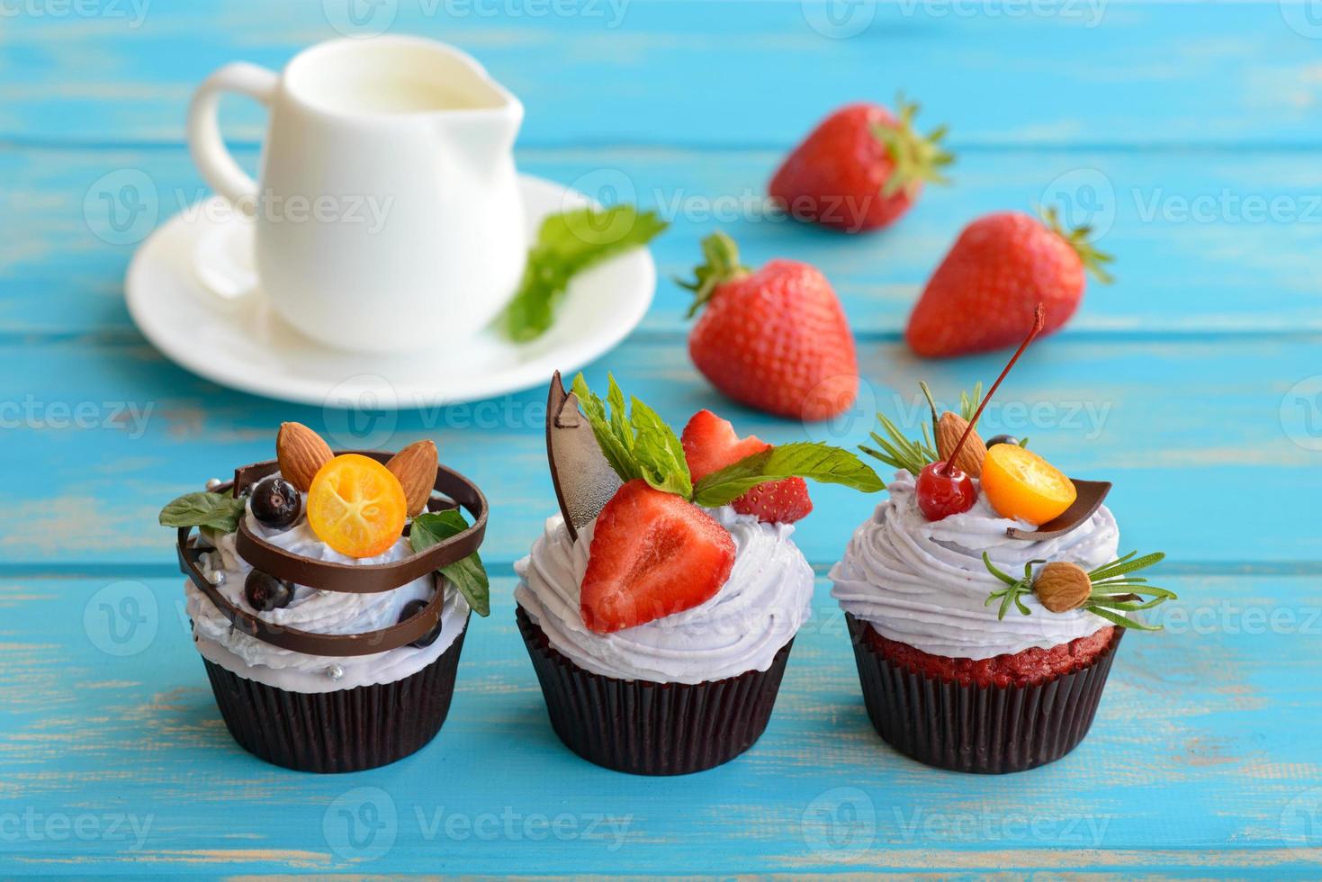 deliciosos pasteles frescos con bayas y crema blanca sobre un fondo azul foto
