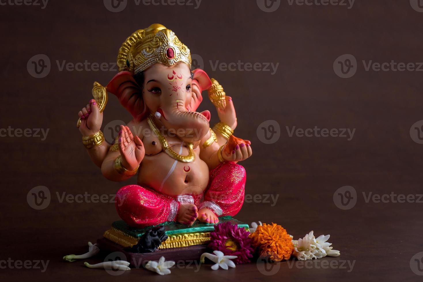 Hindu God Ganesha. Ganesha Idol on dark wooden background. photo