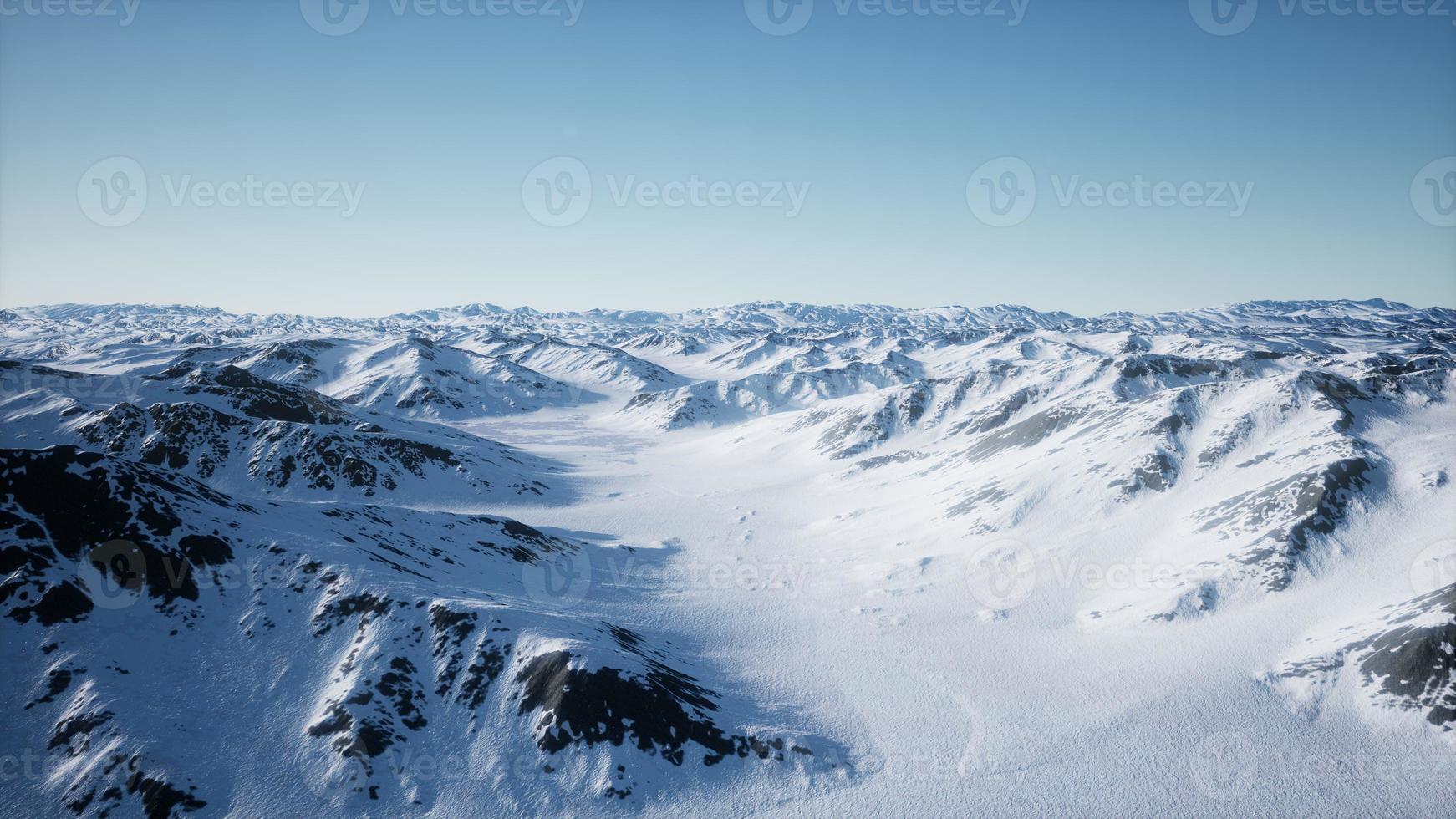 8K Aerial Landscape of snowy mountains and icy shores in Antarctica photo