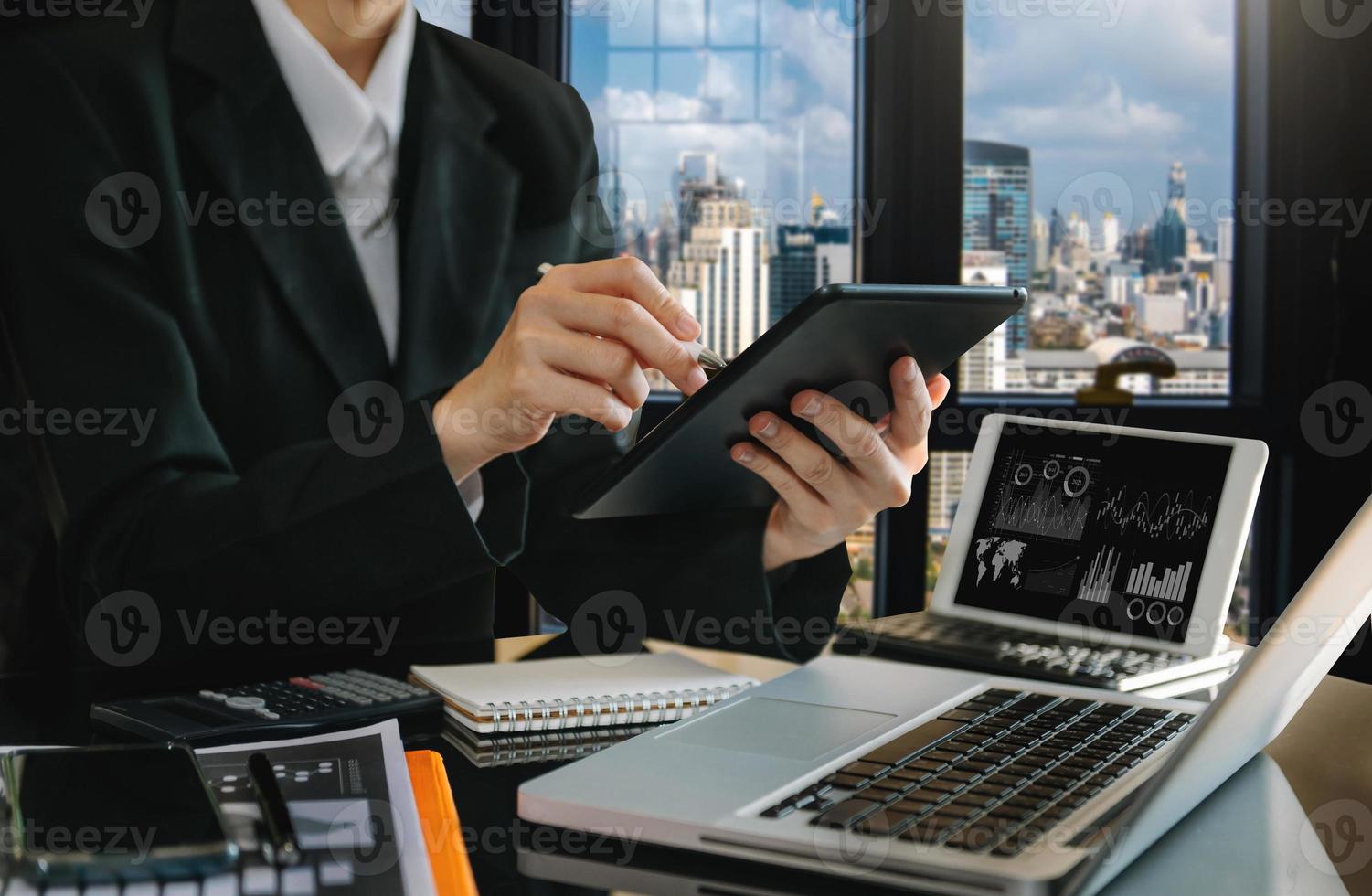 business documents on office table with smart phone and digital tablet and graph financial and woman working photo