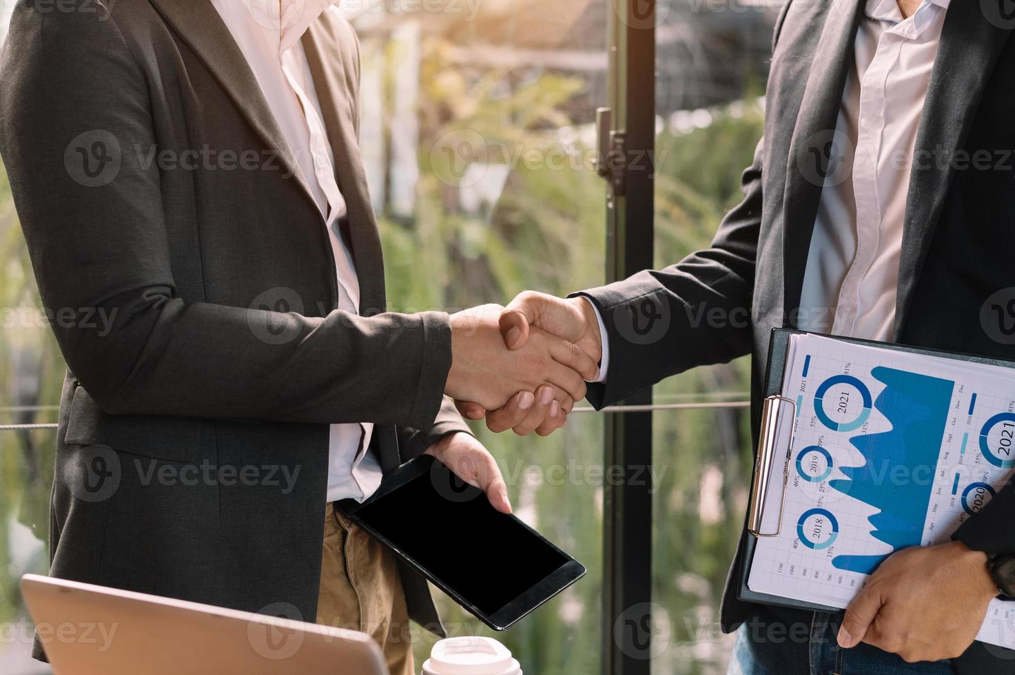 dos hombres de negocios confiados estrechando la mano durante una reunión en la oficina, el éxito y el socio foto