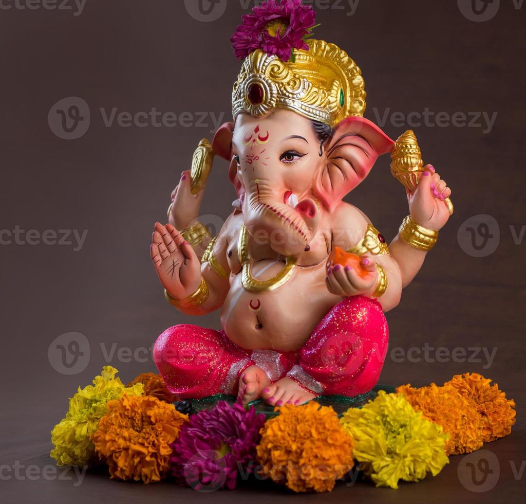 Hindu God Ganesha. Ganesha Idol on dark wooden background. photo