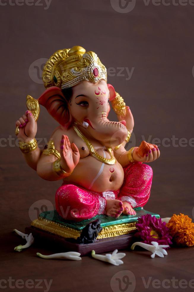 Hindu God Ganesha. Ganesha Idol on dark wooden background. photo
