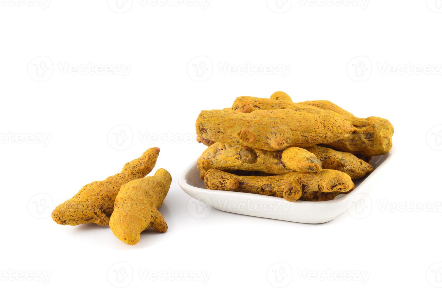 Dry Turmeric roots or barks in white plate isolated on white background photo