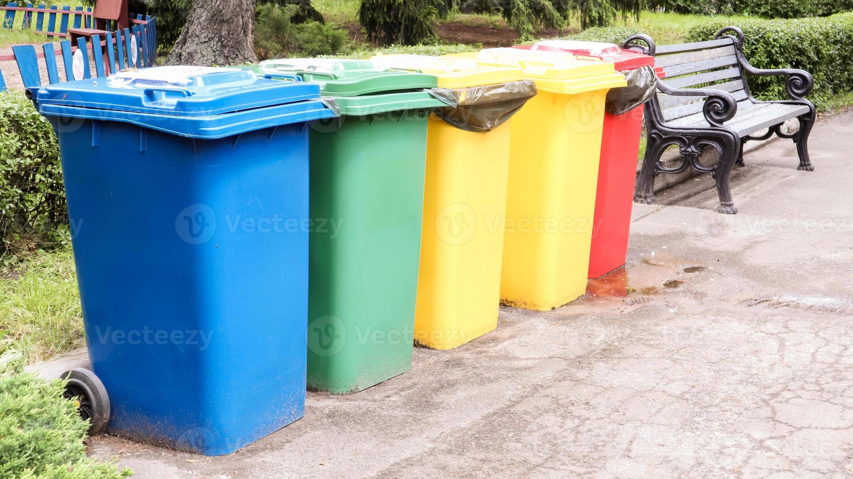 Separate containers for garbage collection in the park. Multi-colored street trash cans on the street. Containers Selective collection of waste. Environmental pollution concept. photo