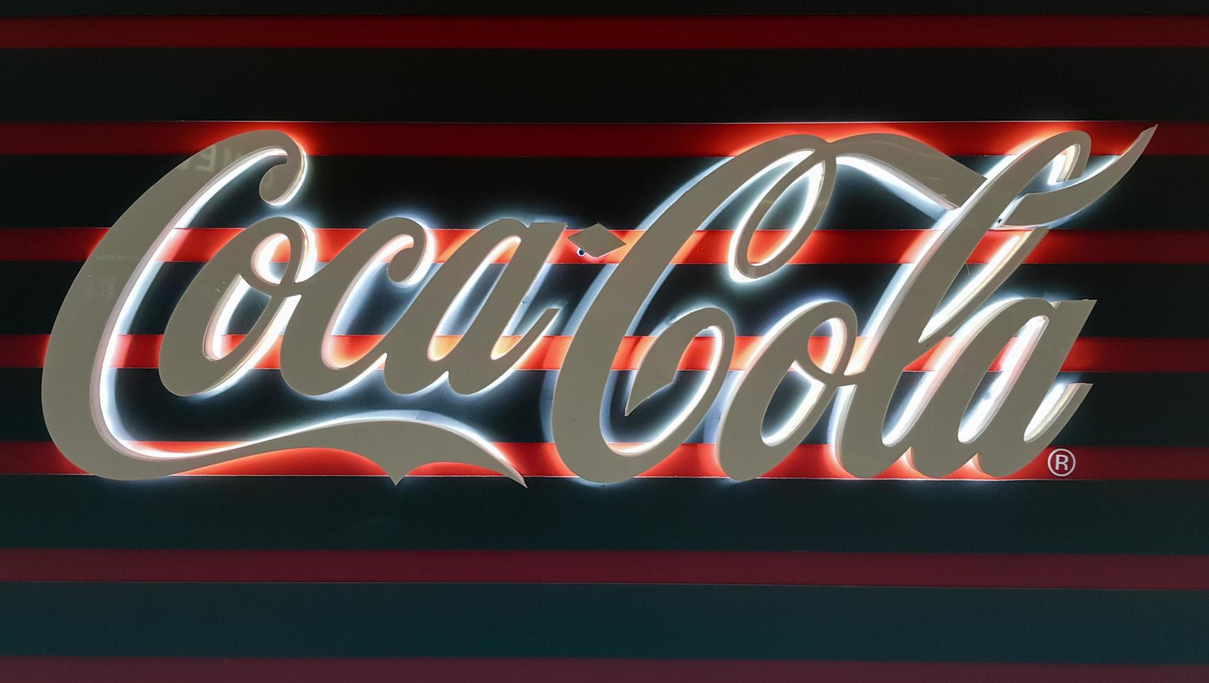 Vista de un letrero de coca-cola blanco brillante en la oscuridad. signo de coca cola. Bebida carbonatada sin alcohol. Ucrania, Kiev - 05 de enero de 2021. foto