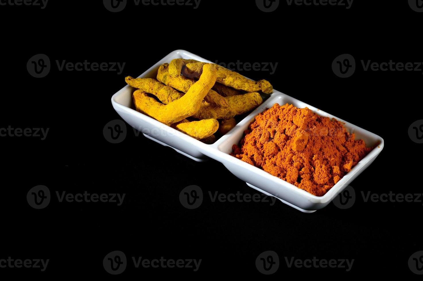 Dry Turmeric powder and roots or barks in white plate photo