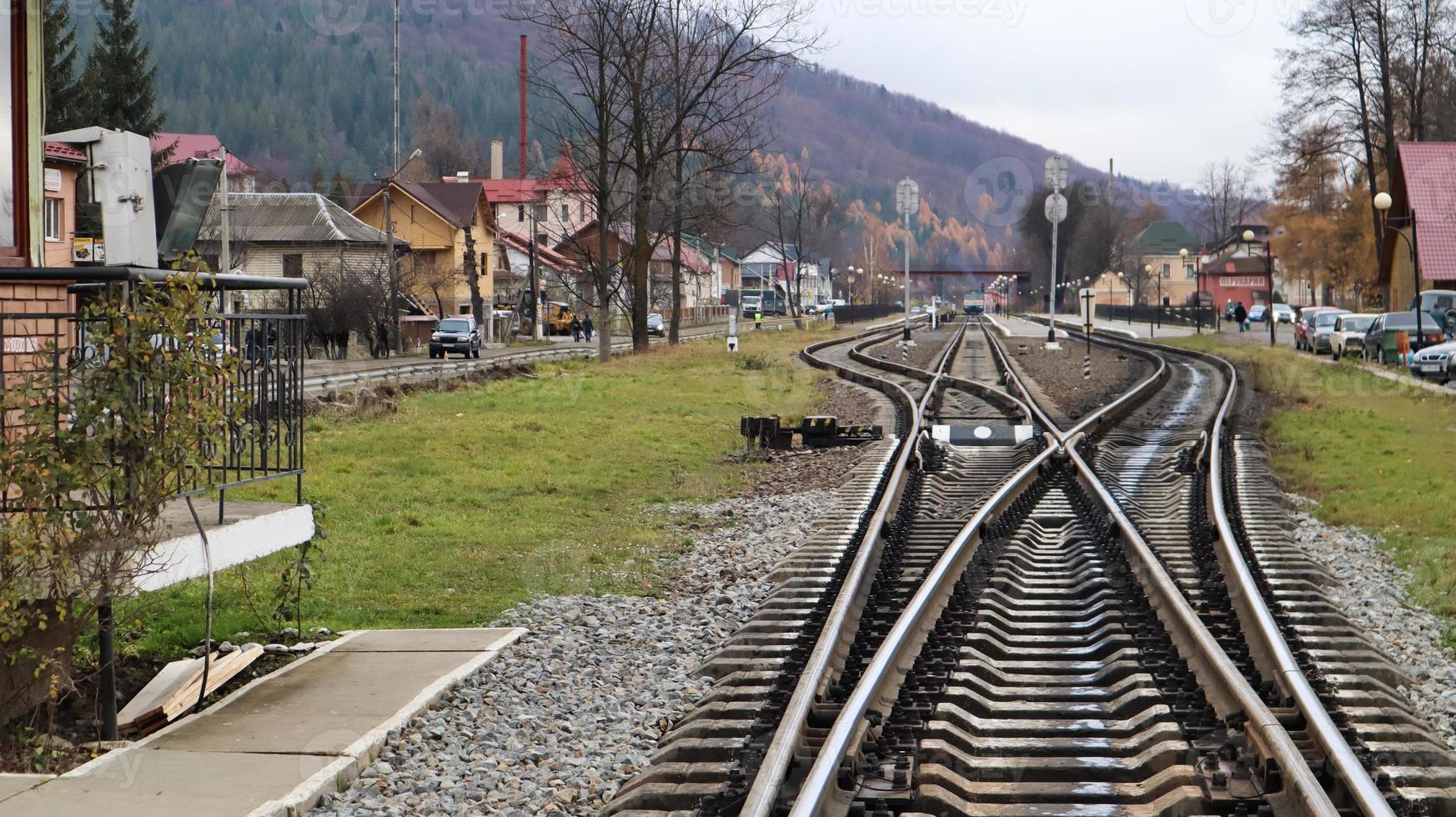 Two railway tracks merge closely. Rails and wooden sleepers. Close-up of tracks. photo