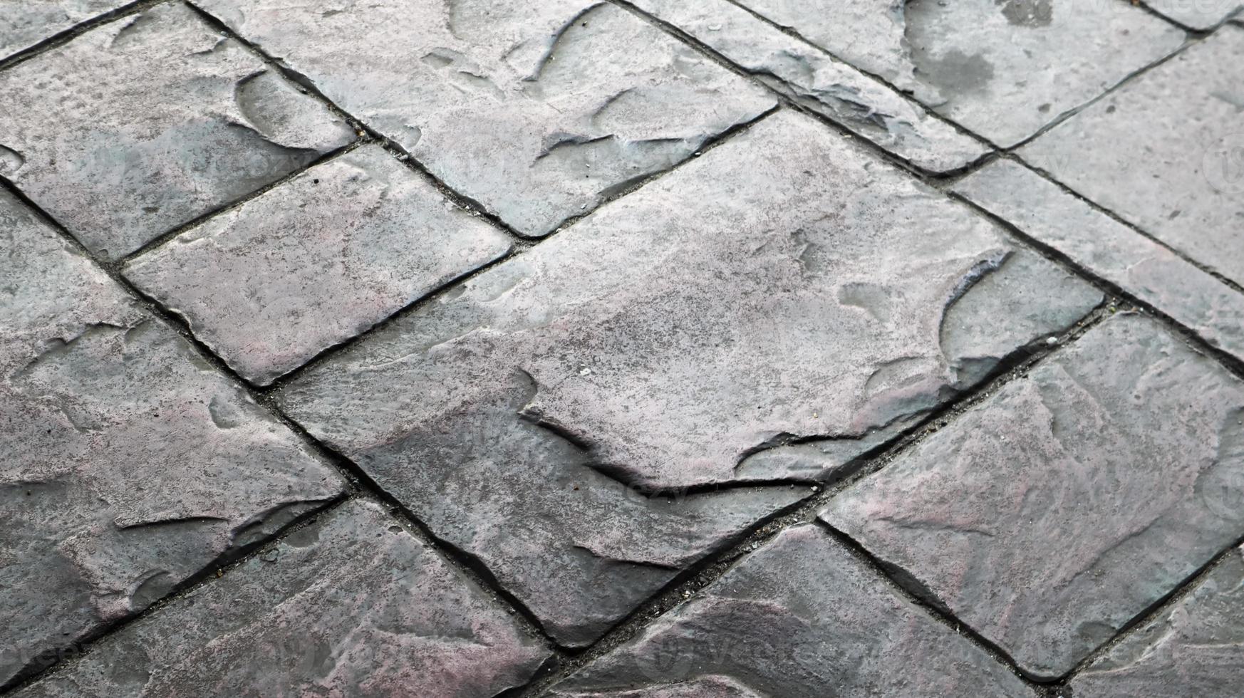 Concrete or cobblestone gray paving slabs or stones for the floor. Pavement in the city. Large gray paving tiles close up. photo
