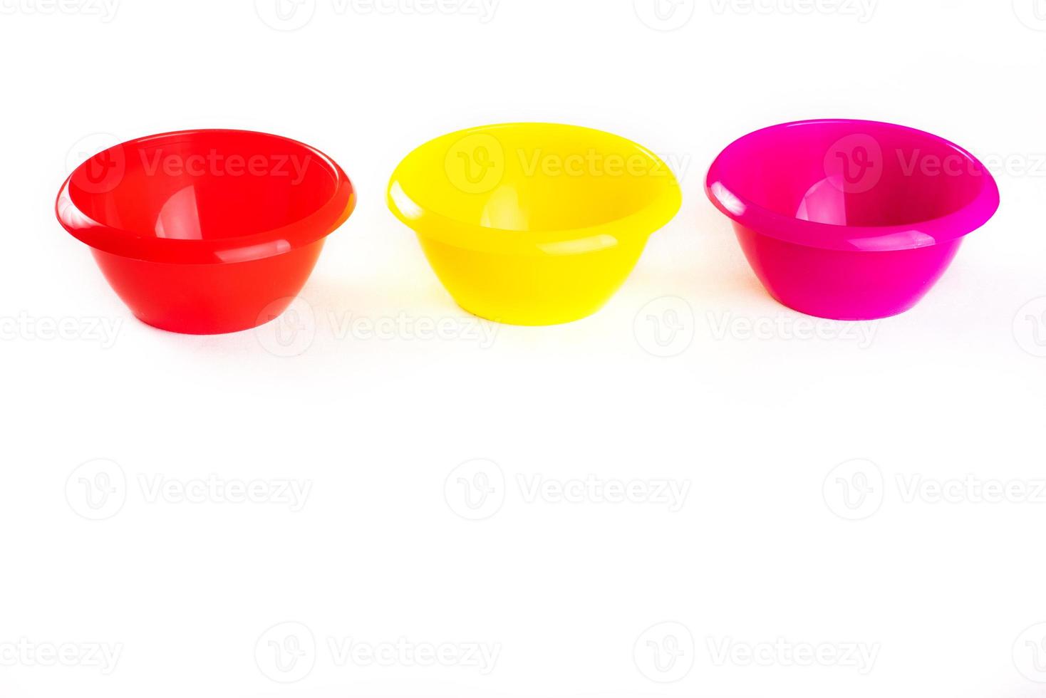 Plastic round bowls of different colors on a white background. Isolate. copy space, top view photo