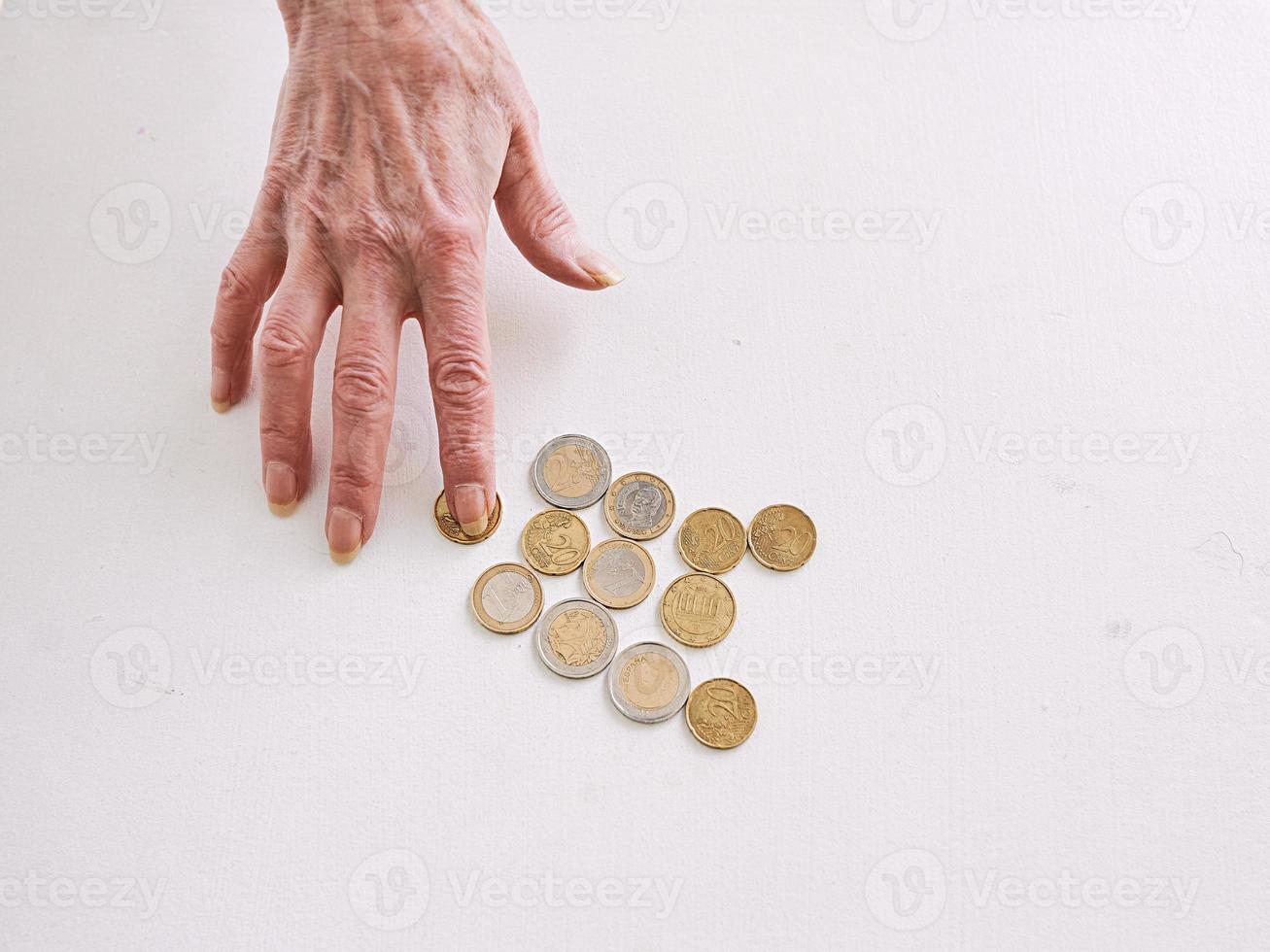 senior hands counting euro coins on the table. poverty, crisis, deposit, recession concept photo