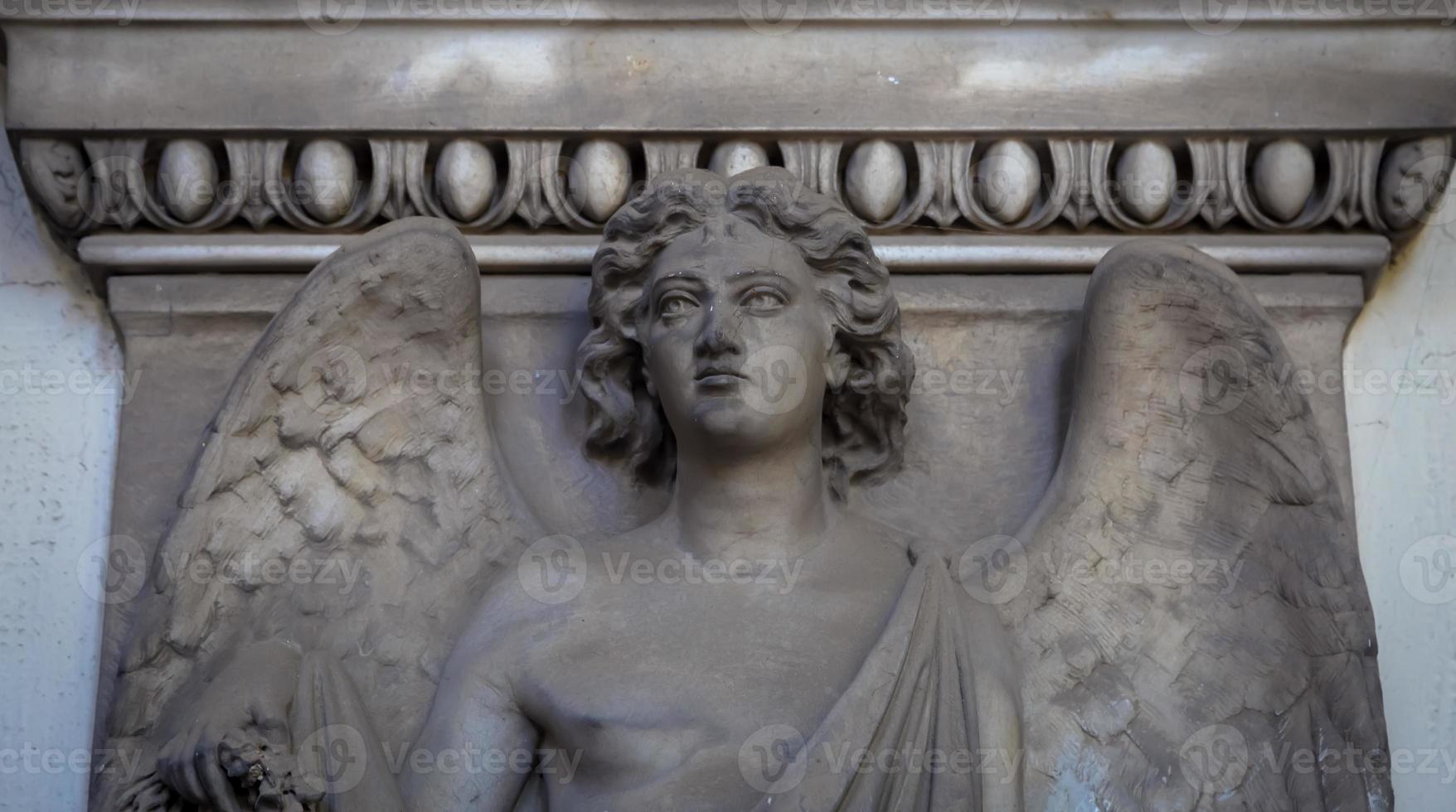 Statue of angel on an old tomb located in Genoa cemetery - Italy photo