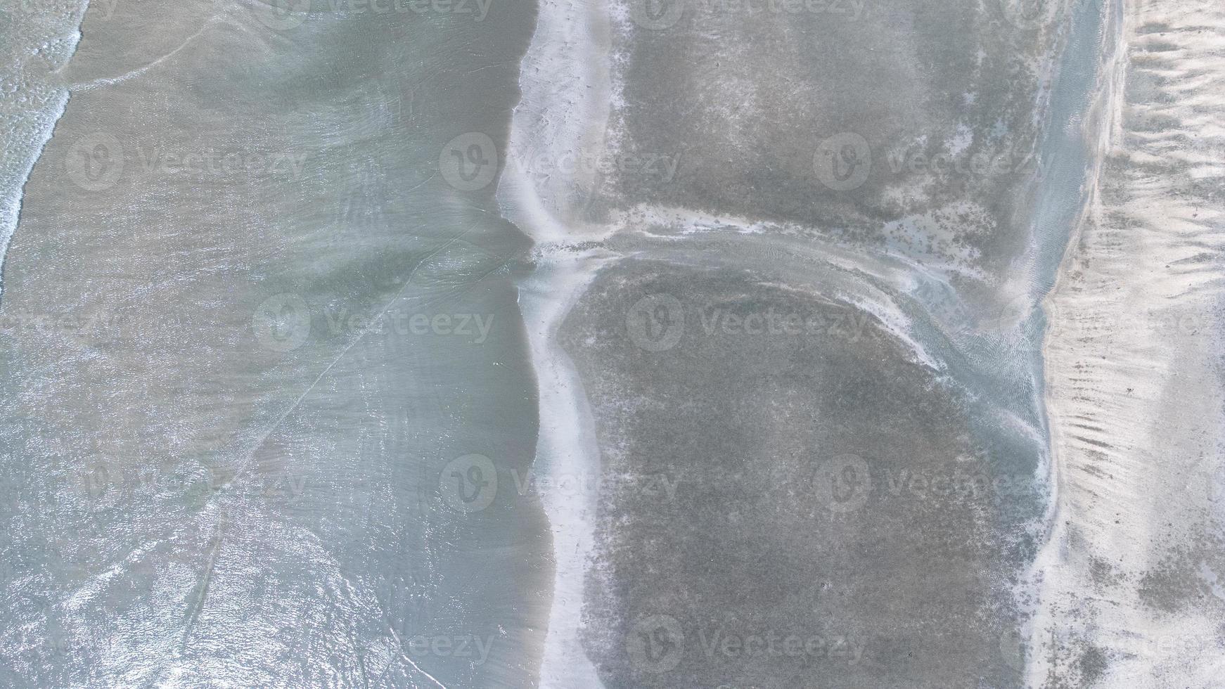 Motion of Soft wave and blue ocean on sandy black beach Background. Black sand beach in Laem Son National Park in Ranong, Thailand photo