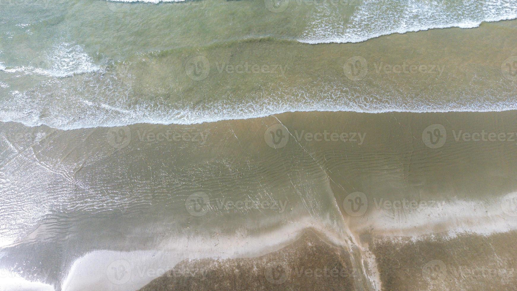 Motion of Soft wave and blue ocean on sandy black beach Background. Black sand beach in Laem Son National Park in Ranong, Thailand photo