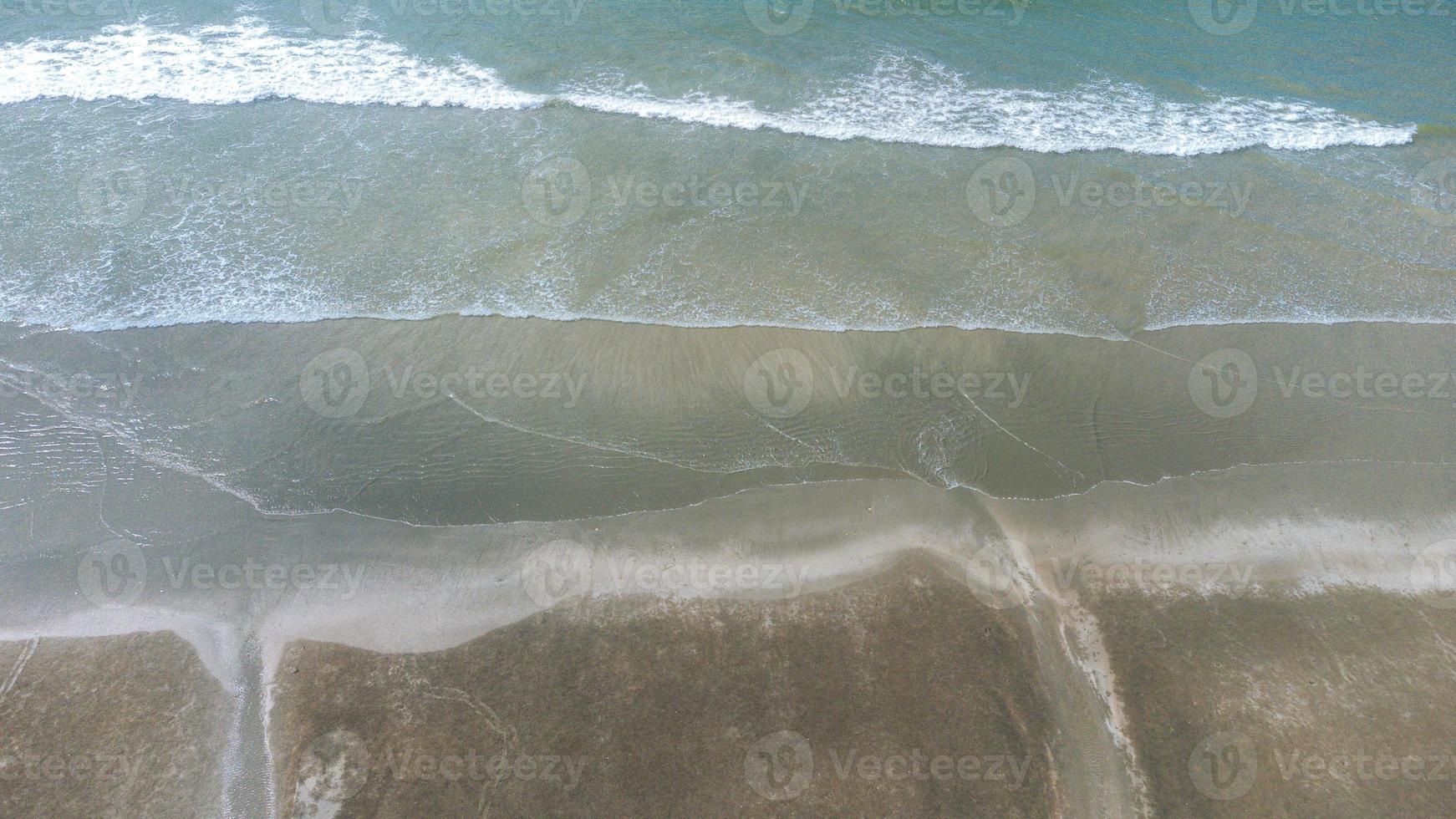 Motion of Soft wave and blue ocean on sandy black beach Background. Black sand beach in Laem Son National Park in Ranong, Thailand photo
