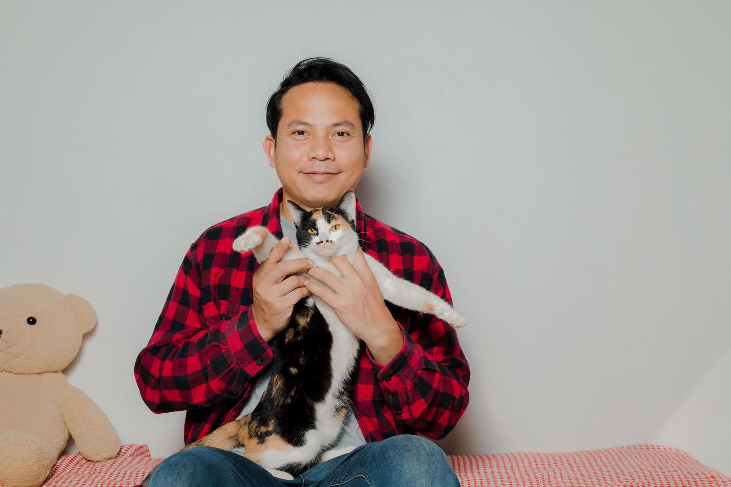 The man used his hand to stroke the cat's head like himself. photo