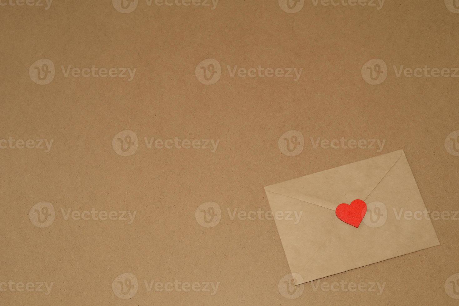 Valentine's day. Envelope with red heart on a background of kraft paper, copy space. February 14th photo