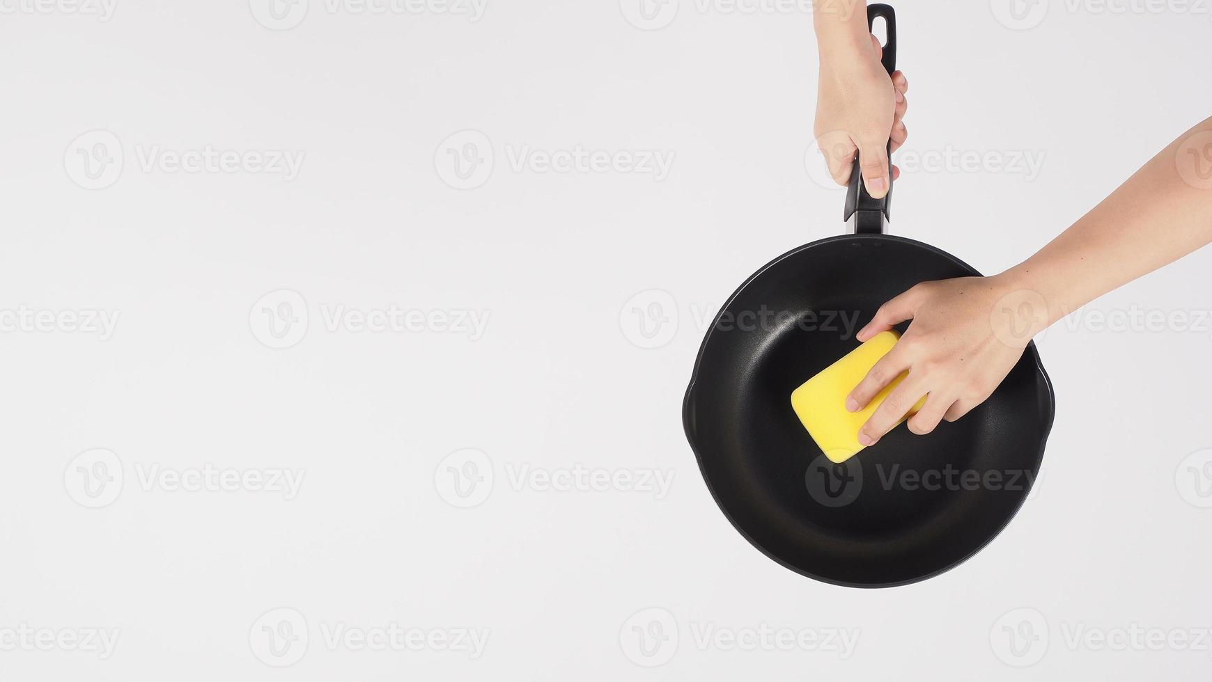 Hand cleaning the non stick pan with handy dish washing sponge