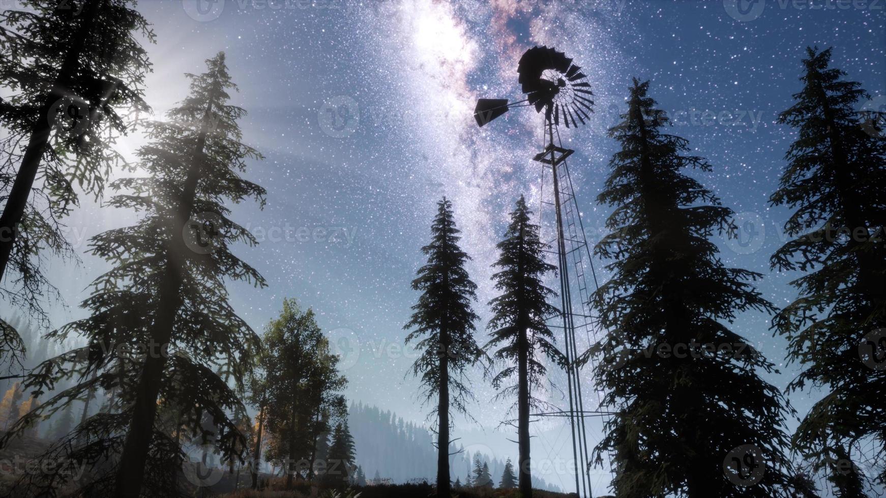 Retro Windmill in Mountain Forest photo