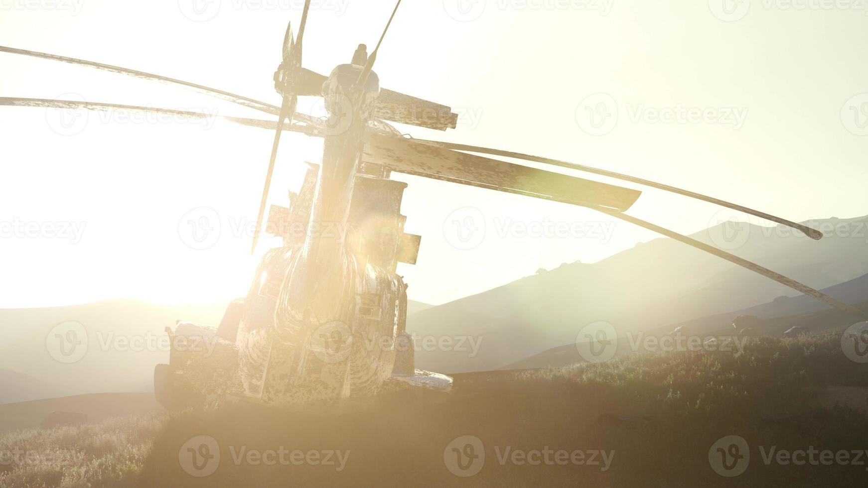 old rusted military helicopter in the desert at sunset photo