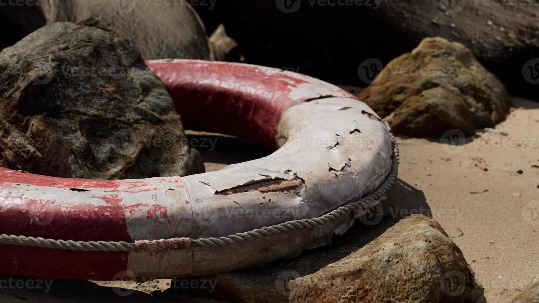 old Life Buoy on sand in sunset photo