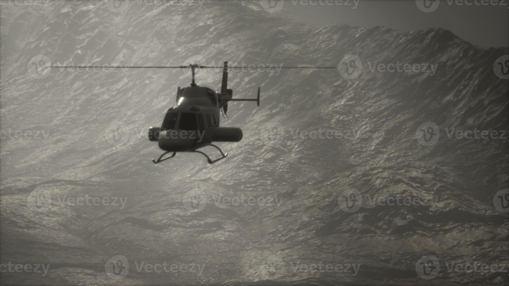 Helicóptero volador en cámara lenta extrema cerca de montañas con niebla foto