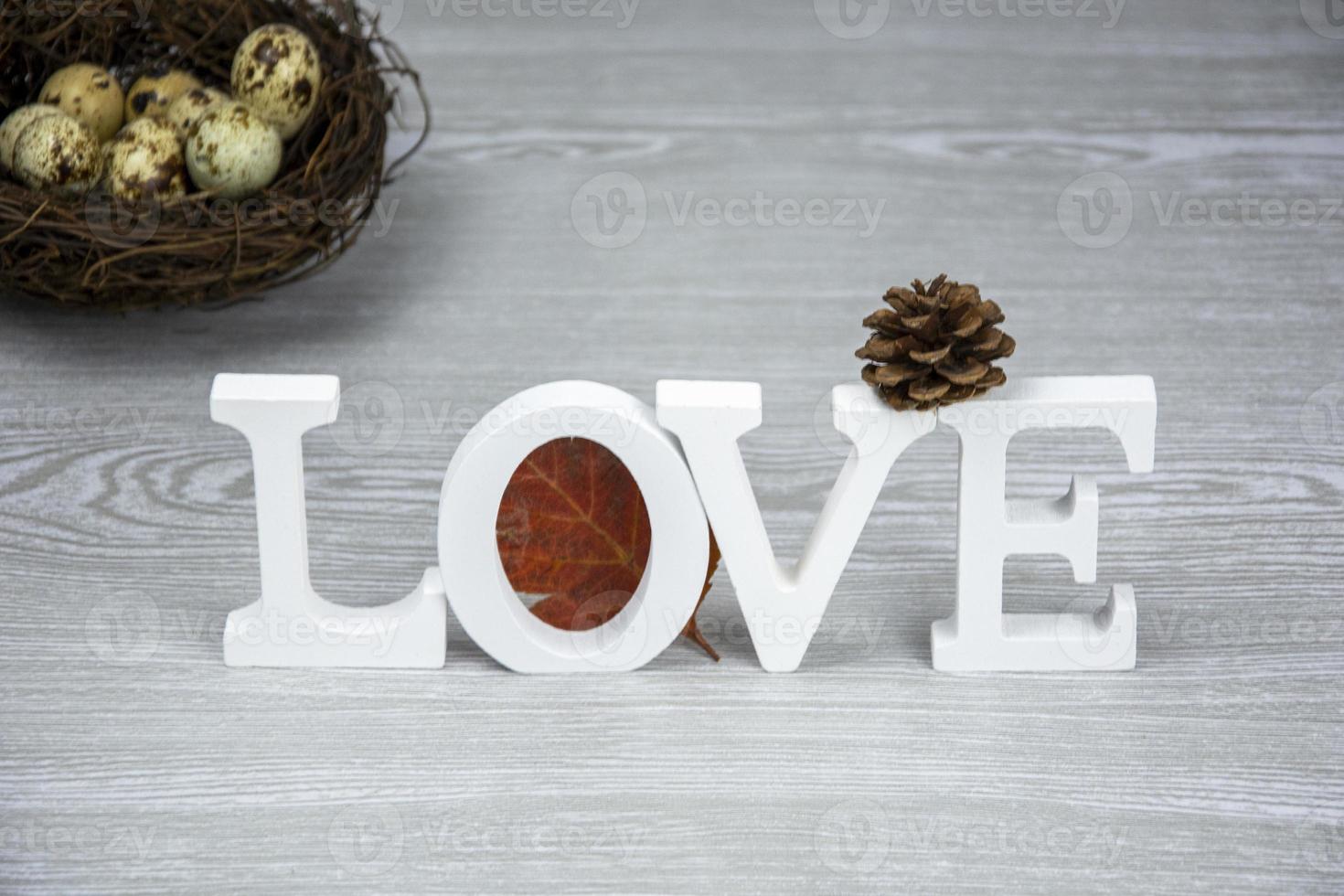 Word LOVE from wooden letters. Selective focus. Easter card with nest and eggs. photo