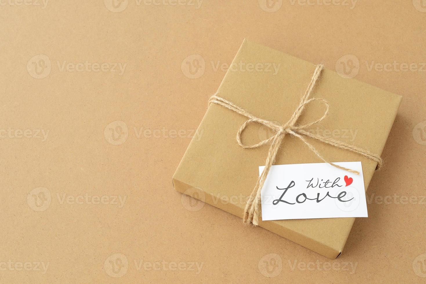 Gift box in kraft paper with With love card on a cardboard background, copy space. Valentines day photo