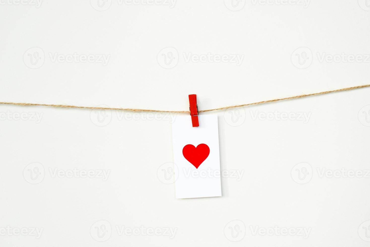 Valentine's Day card with red heart hanging on a rope on clothespin. February 14. Love background photo