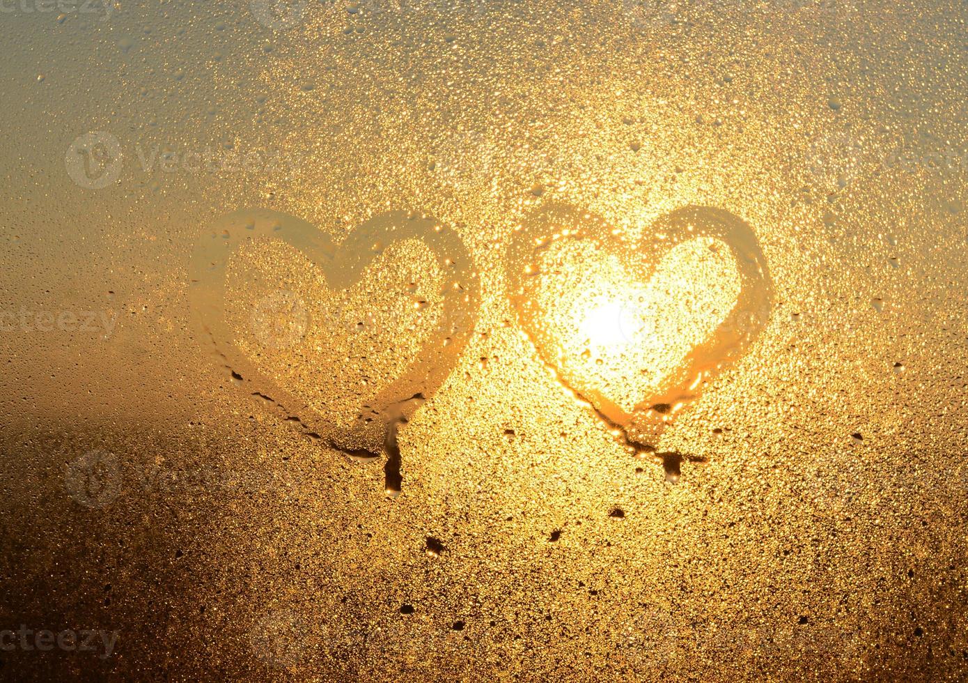2 lovers hearts drawn with a finger on the fogged window glass. Valentines Day, valentines, creative photo
