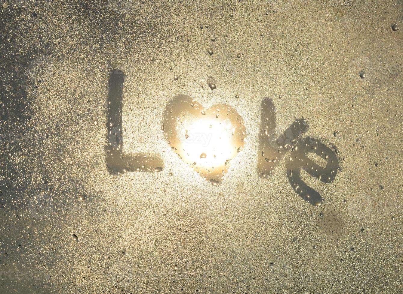 Word Love, shape heart are drawn with finger on fogged window glass. Valentines Day, Valentine card photo