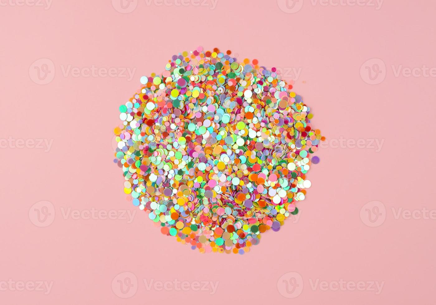 Circle of colored confetti on pink background, top view. Colorful celebration background, copy space photo