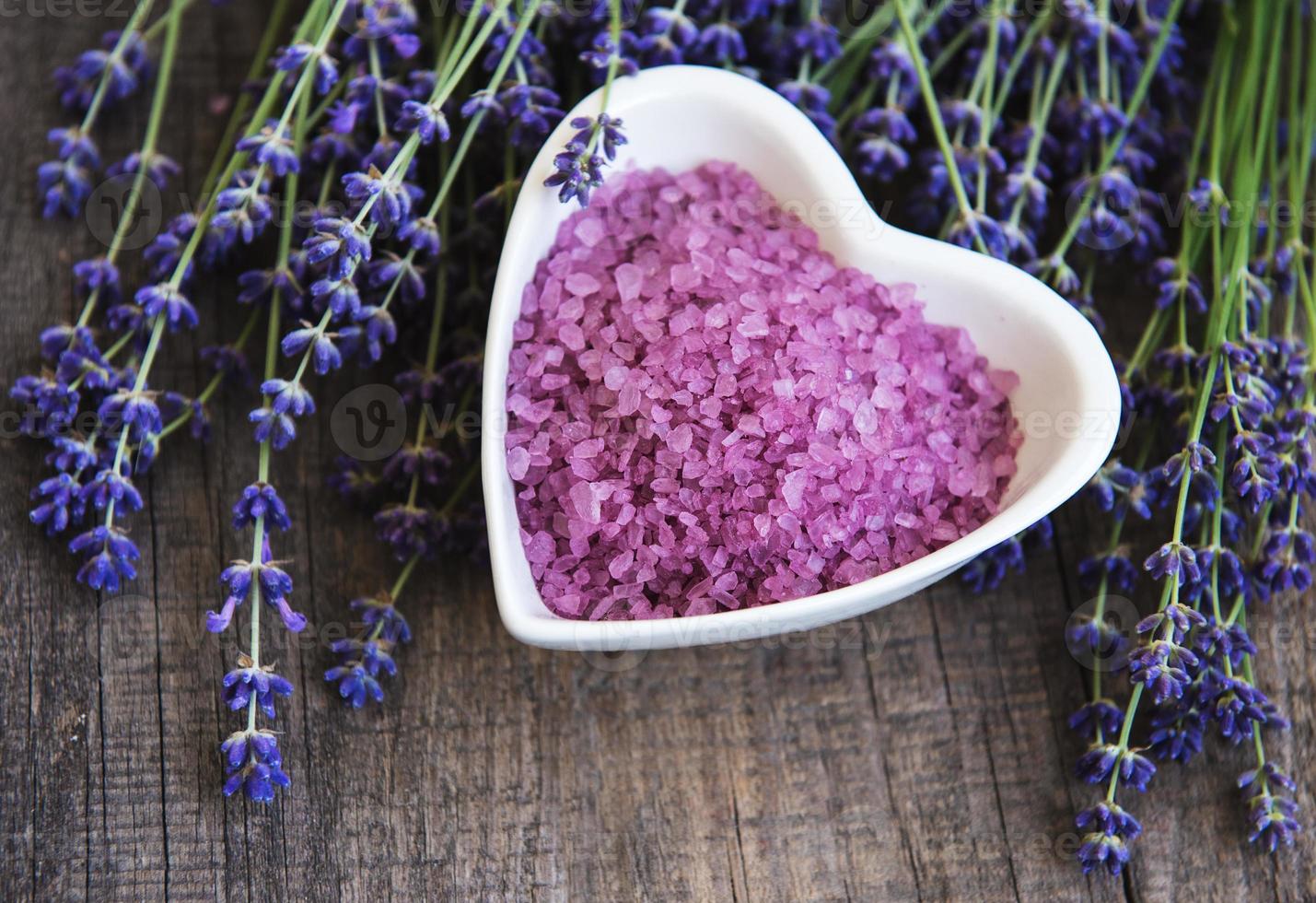 cuenco en forma de corazón con sal marina y flores frescas de lavanda foto