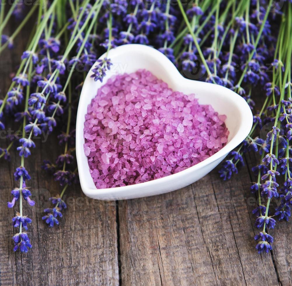 cuenco en forma de corazón con sal marina y flores frescas de lavanda foto