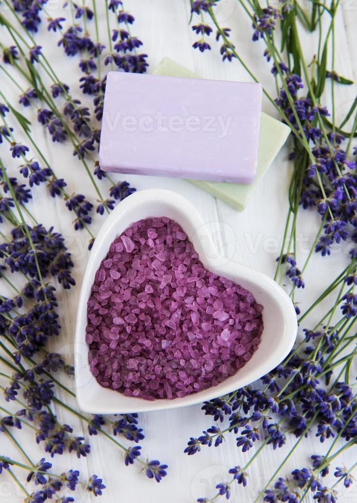 Heart-shaped bowl with sea salt, soap and fresh lavender flowers photo