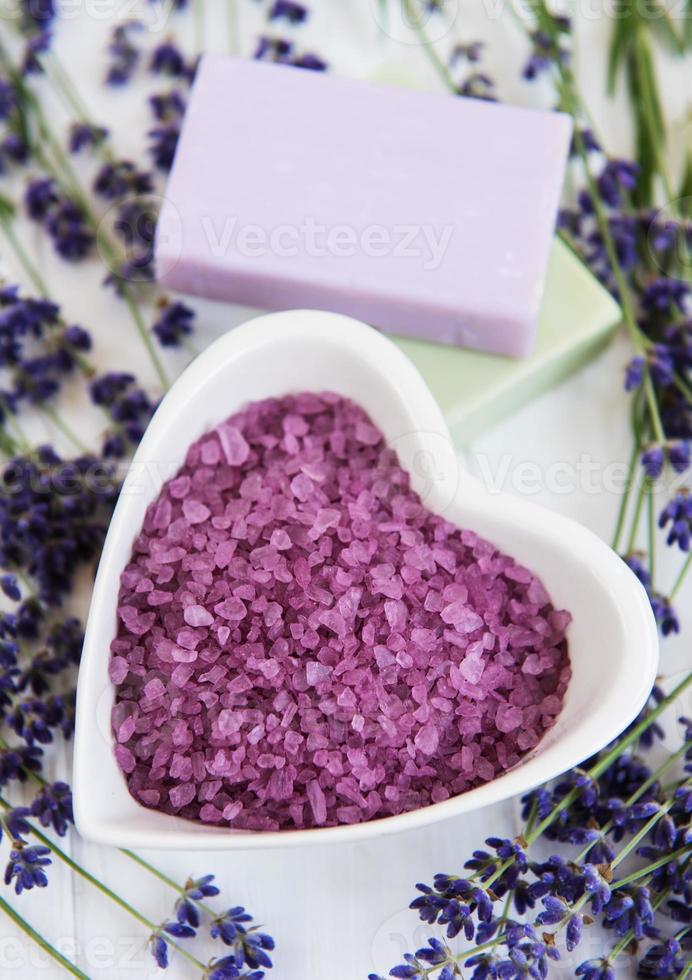 Heart-shaped bowl with sea salt, soap and fresh lavender flowers photo