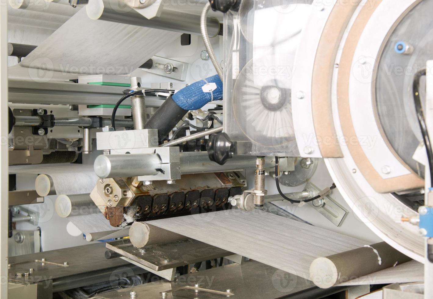 equipment and mechanism with a moving cloth tape on rollers closeup. in the production of moving fabric tape on network rollers photo