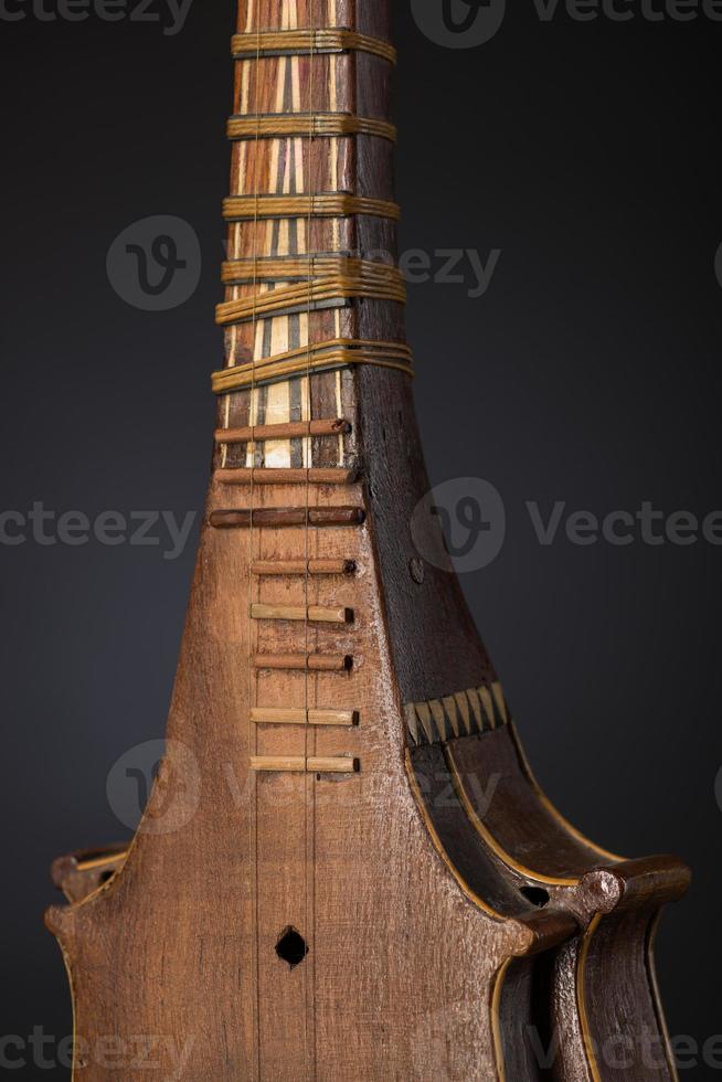 part ancient Asian stringed musical instrument on black background with backlight photo