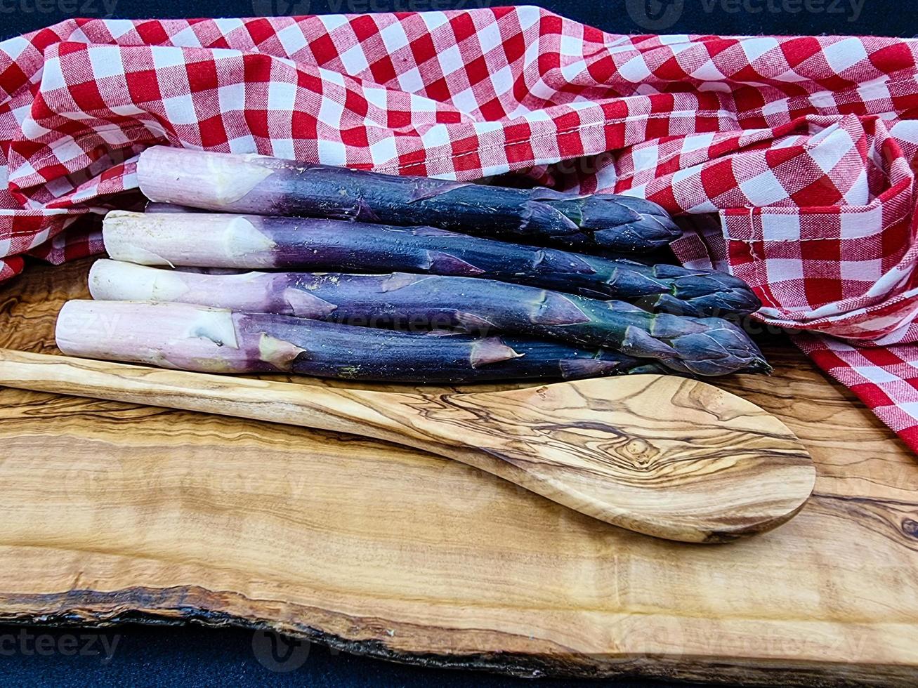 purple Asparagus officinalis a saisonal vegetable on olive wood photo