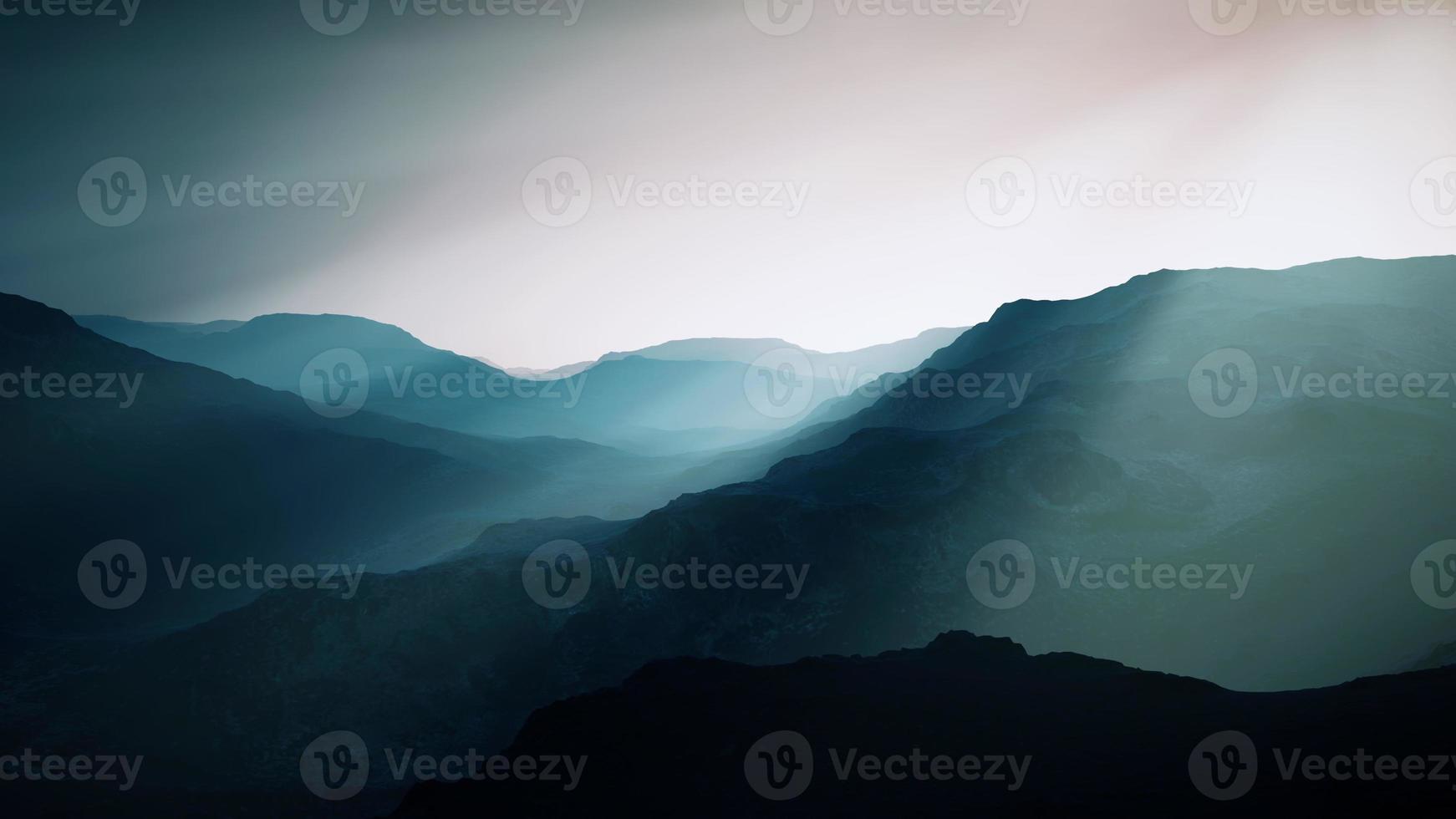 black rocky mountain silhouette in deep fog photo