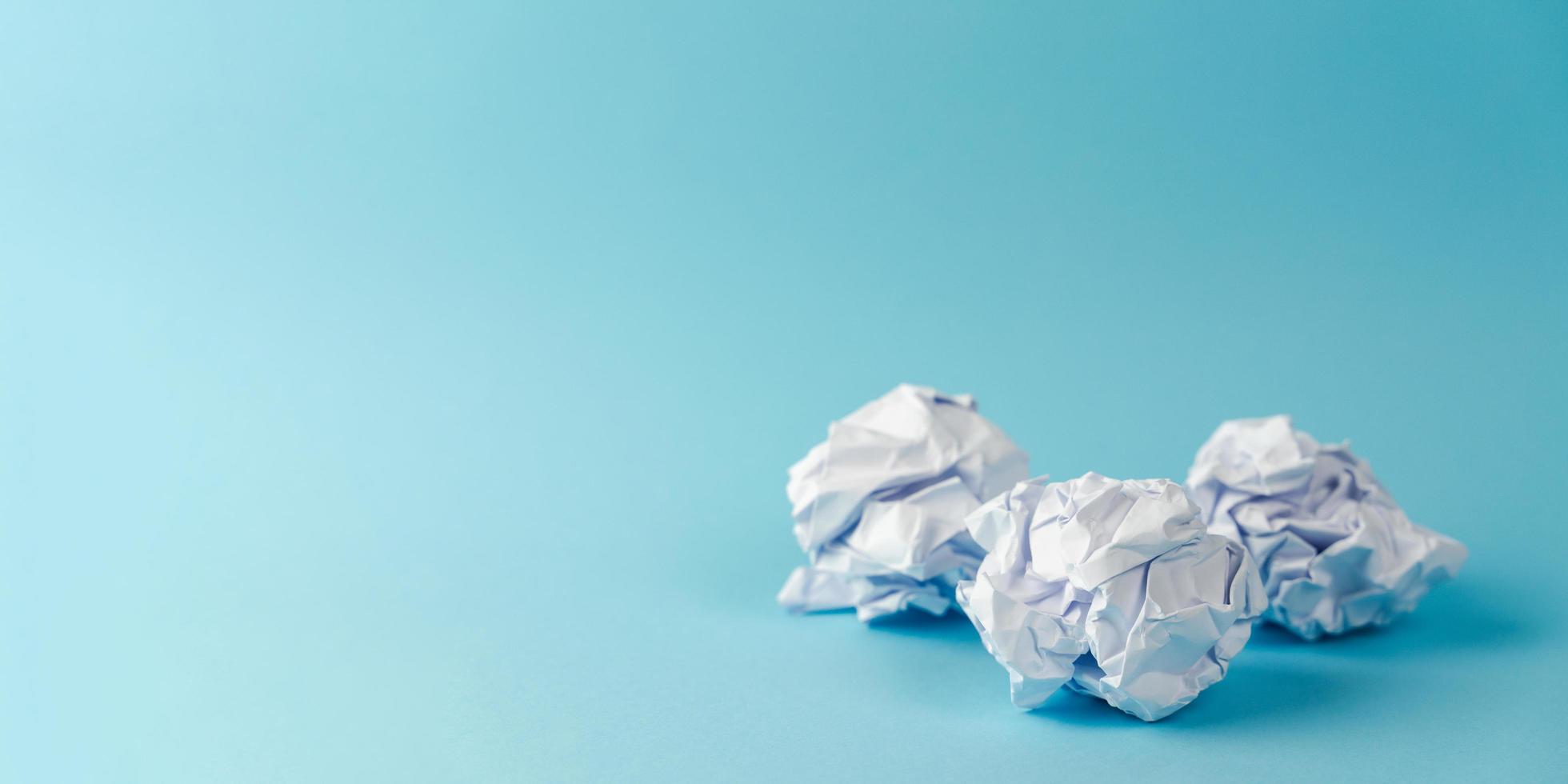 Crumpled paper balls on a blue background. Idea, Mistake , Waste, Recycle Concept. photo