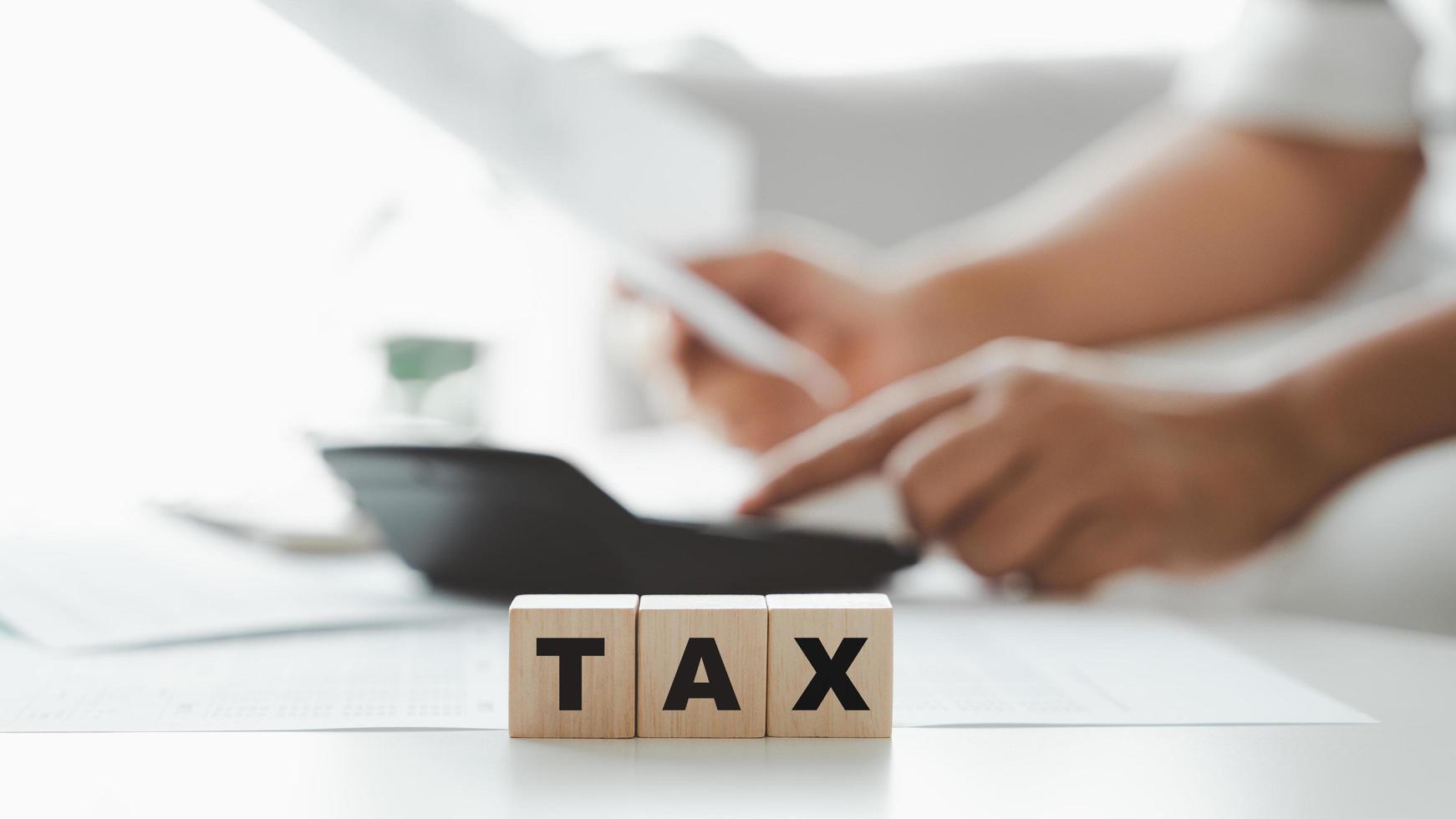 Woman is calculating annual tax, monthly expenses with calculator and filling form of Individual Income Tax Return. Season to pay Tax and Budget planning concept. photo
