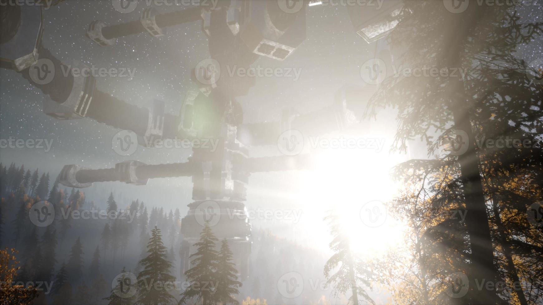 UFO hovering over a forest at night with light beam photo