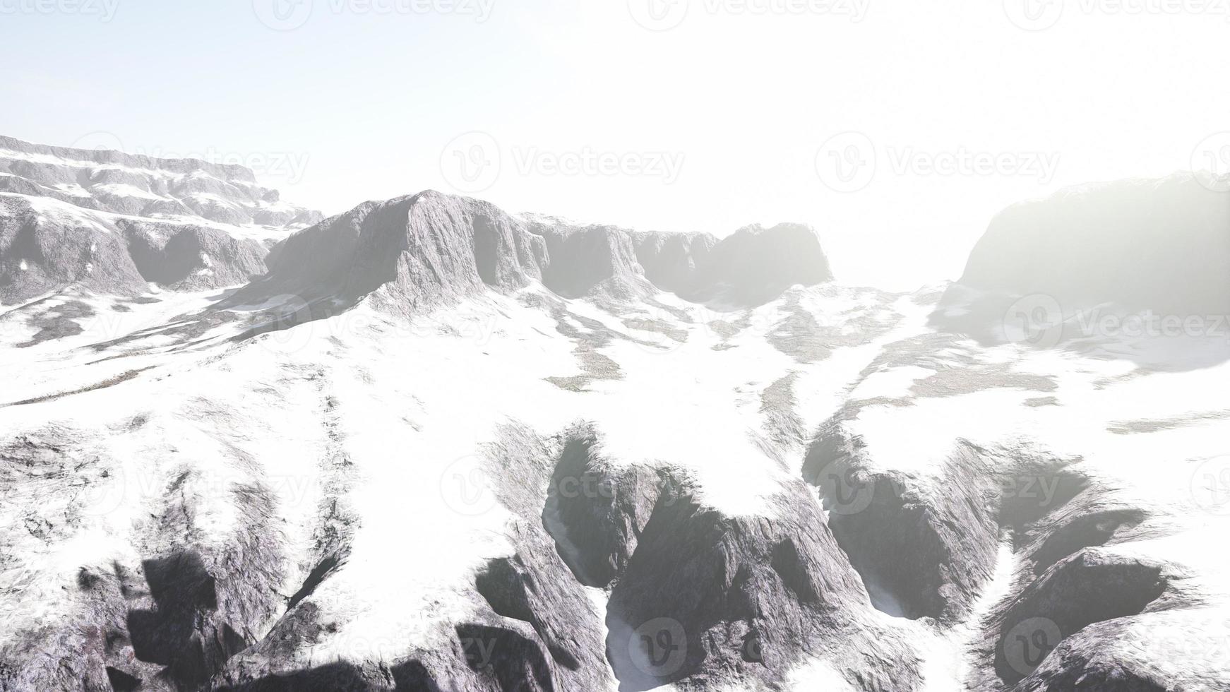 snowy mountains with deep ravine and rock cliffs photo